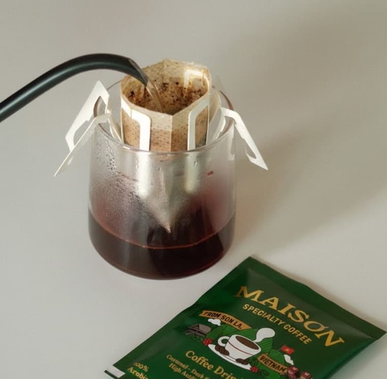 Maison Specialty drip coffee bag brewing into a cup
